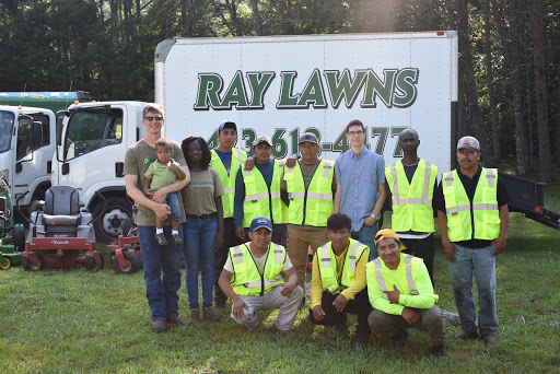 The Ray Lawns team from Chattanooga standing in front of their fleet of landscaping equipment.